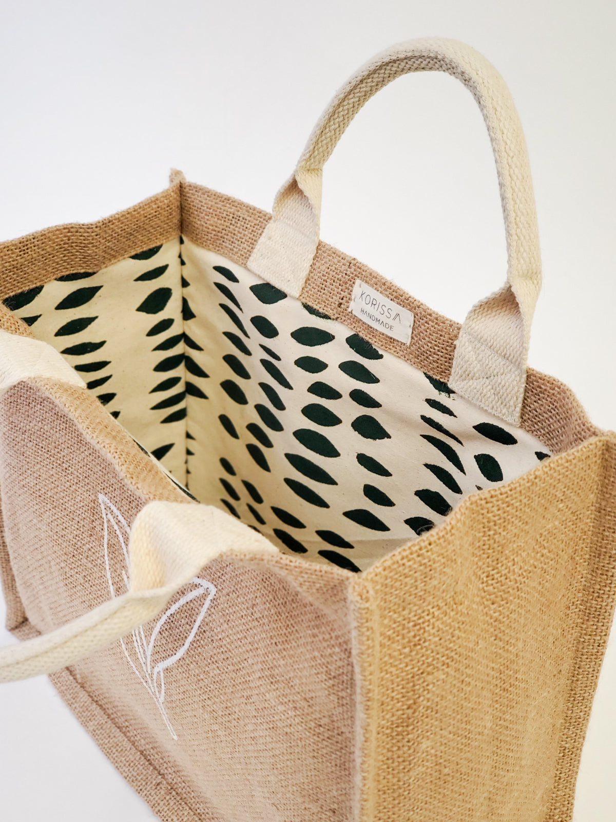 Jute Market Bag. Reusable. Leaf Patter Print. Approximately10” tall x 12.5” wide x 6" deep. Canvas lining with cotton. Colors Natural, White, Green.