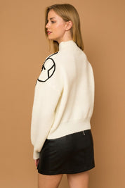 Flower Embroidery Mock Neck Sweater. white knit sweater with large black embroidered flowers.