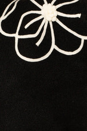 Flower Embroidery Mock Neck Sweater. Black knit sweater with large white embroidered flowers.