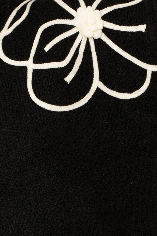 Flower Embroidery Mock Neck Sweater. Black knit sweater with large white embroidered flowers.