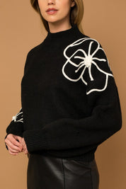 Flower Embroidery Mock Neck Sweater. Black knit sweater with large white embroidered flowers.