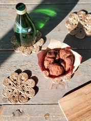 Approximately 4” round. sustainably handmade. braided jute. drink coasters. flower shaped drink coaster. 