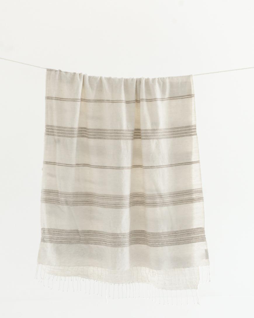 Ethically crafted in Ethiopia. Cotton throw blanket. Measures 38 x 72 inches. natural with stone. 